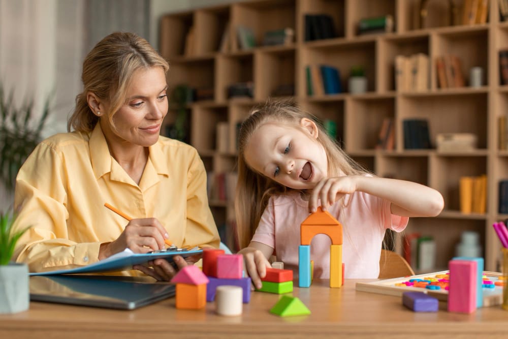 child-psychology-exam-little-girl-playing-with-colorful-wooden-blocks-professional-kids-psychologist-writing-notes