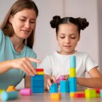 young-female-psychologist-helping-girl-speech-therapy-min